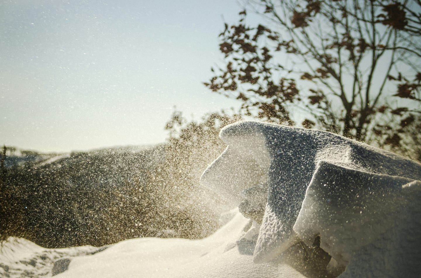 A mini-split outdoor condenser running in falling snow