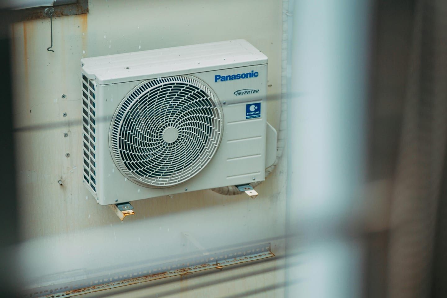 Outdoor mini-split condenser running in a snowy Keene winter